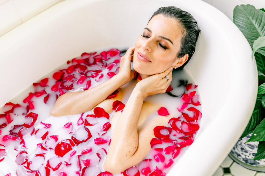 Lady in a bath with milk and rose petals
