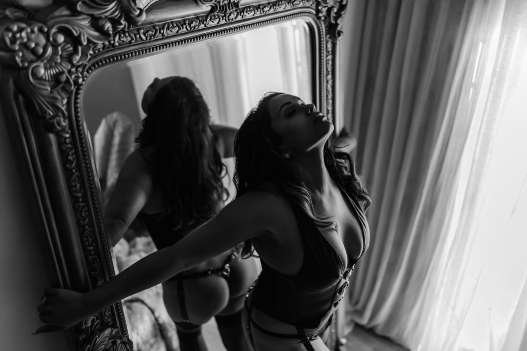 Boudoir photography Sydney black and white image of a woman in front of a mirror.